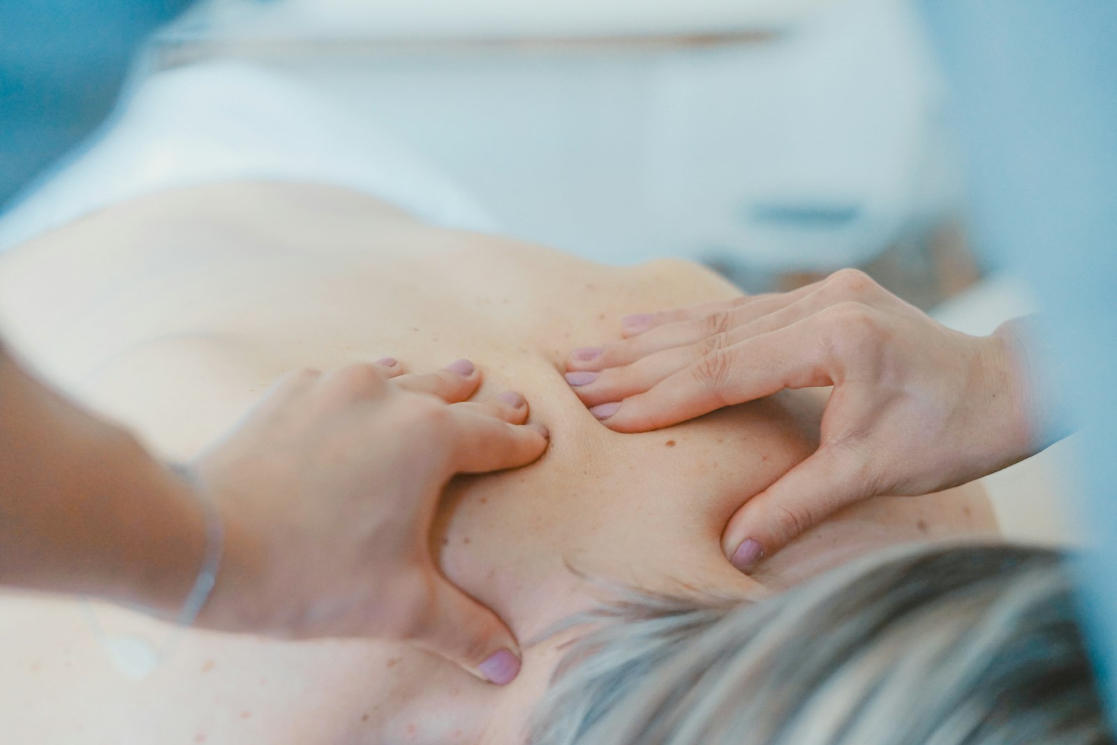 A massage therapist working on a client's upper back