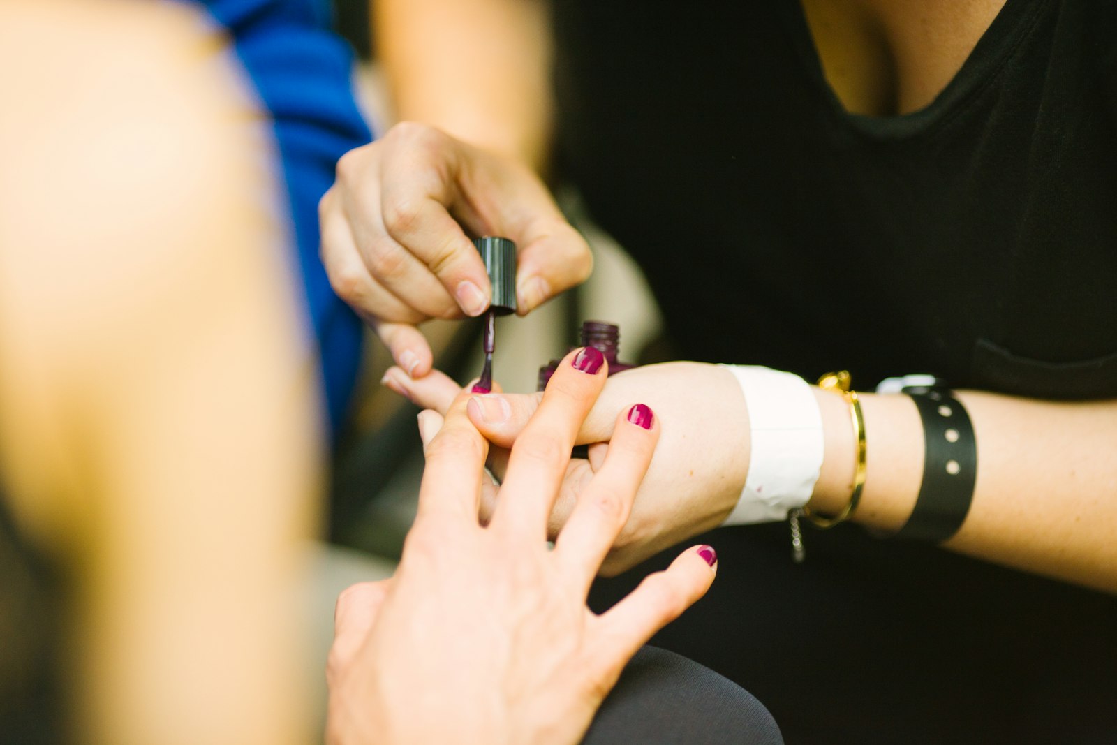 A nail technician filing a client's nails