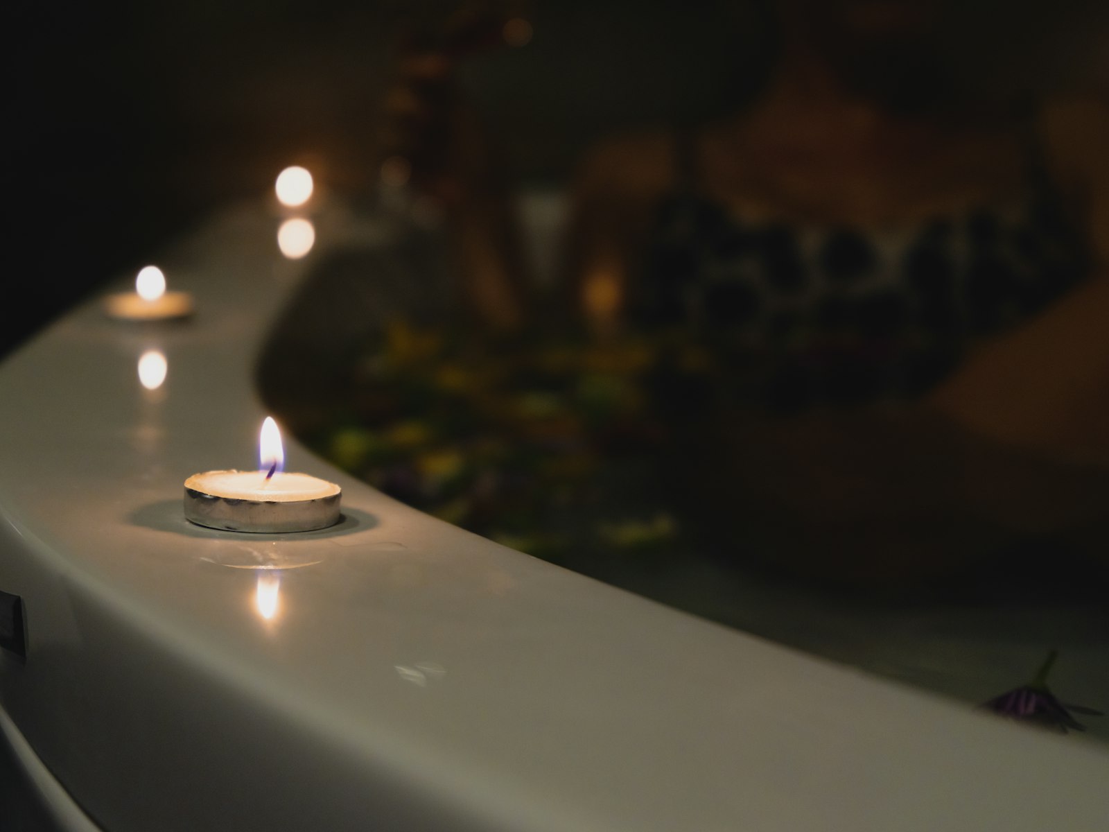 Lit candles on a table in a dim spa room